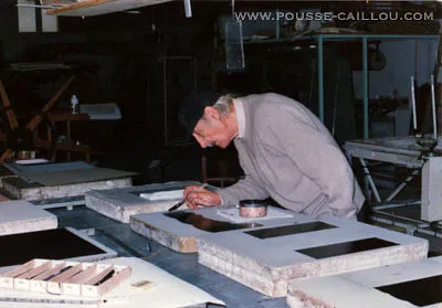 Photographie de Mathias Spescha en train de peindre sur des pierres lithographiques de l'atelier Pousse Caillou - Crédit photo : Luc Valdelièvre